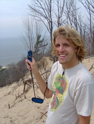 Brent Geurink measures wind conditions at the crest of a dune near the study area..