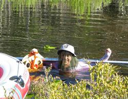 Student carrying a livingston corer to the raised center of a peat bog.