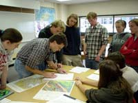 Faculty and students working with maps