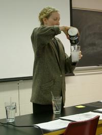 instructor pouring salt into glass of drinking water