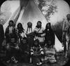 Crow tribe members in front of a teepee.