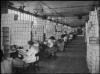 Workers box shoes at a factory